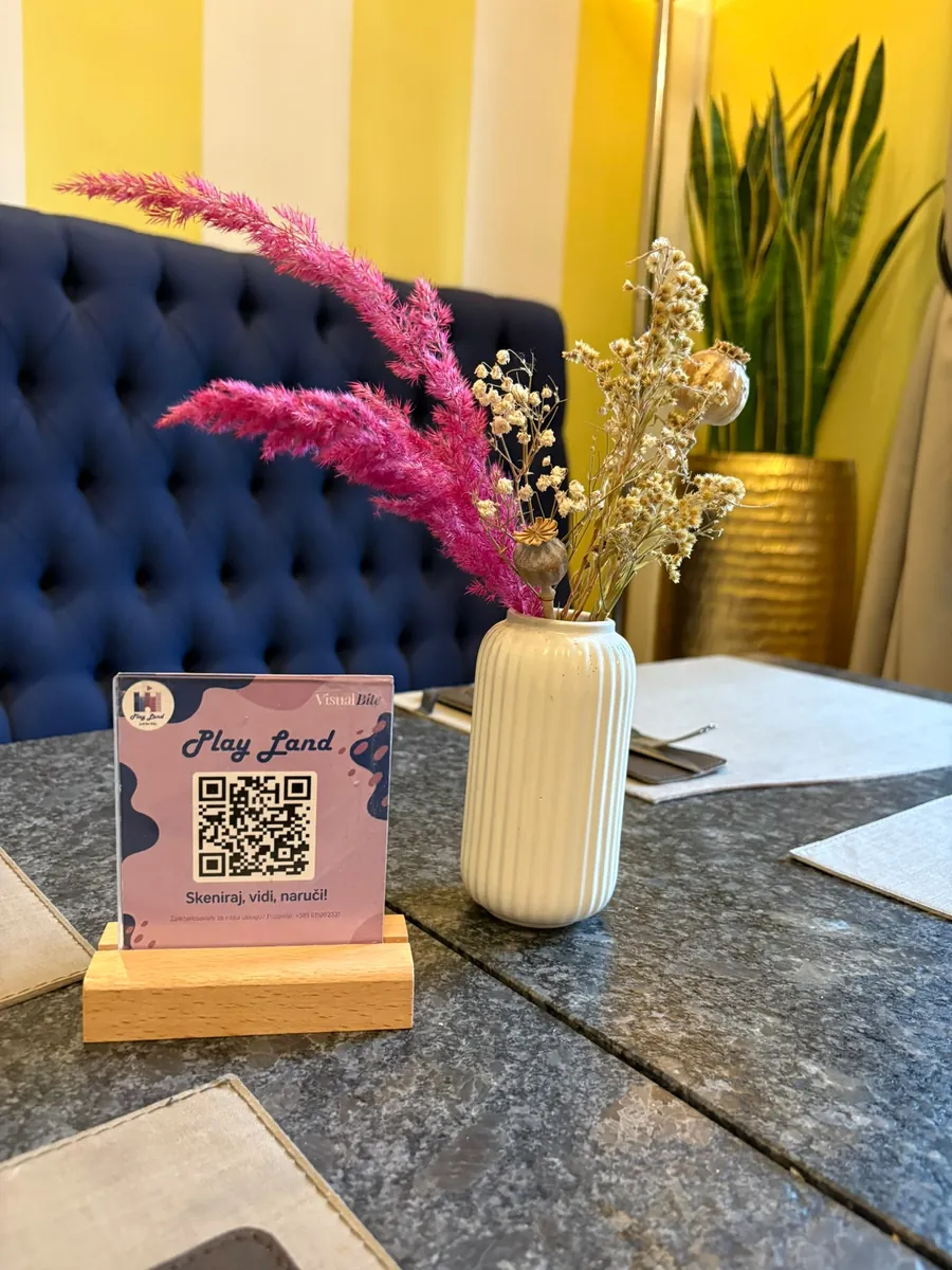 VisualBite QR-Aufsteller im Play Land neben Blumen